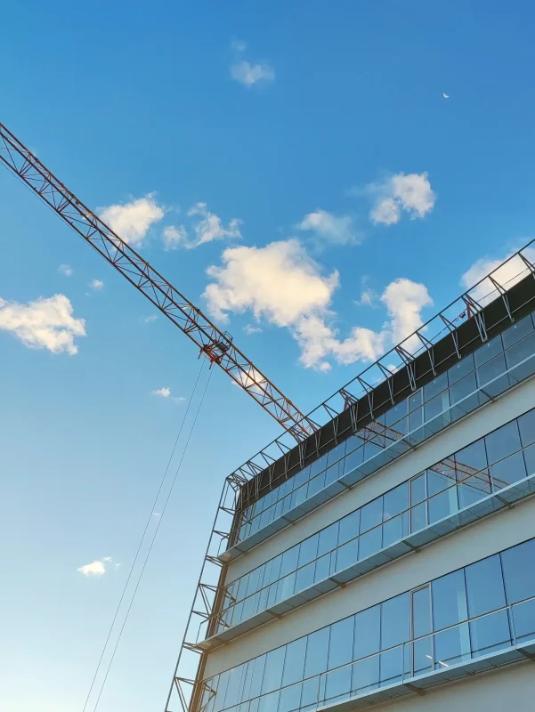 Large structural steel building under construction with crane